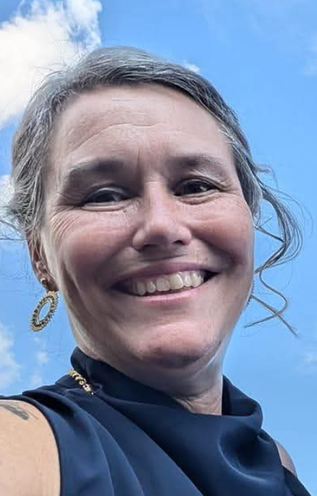 Sophie Lajeunesse, psychoéducatrice, souriante en extérieur sous un ciel bleu.
